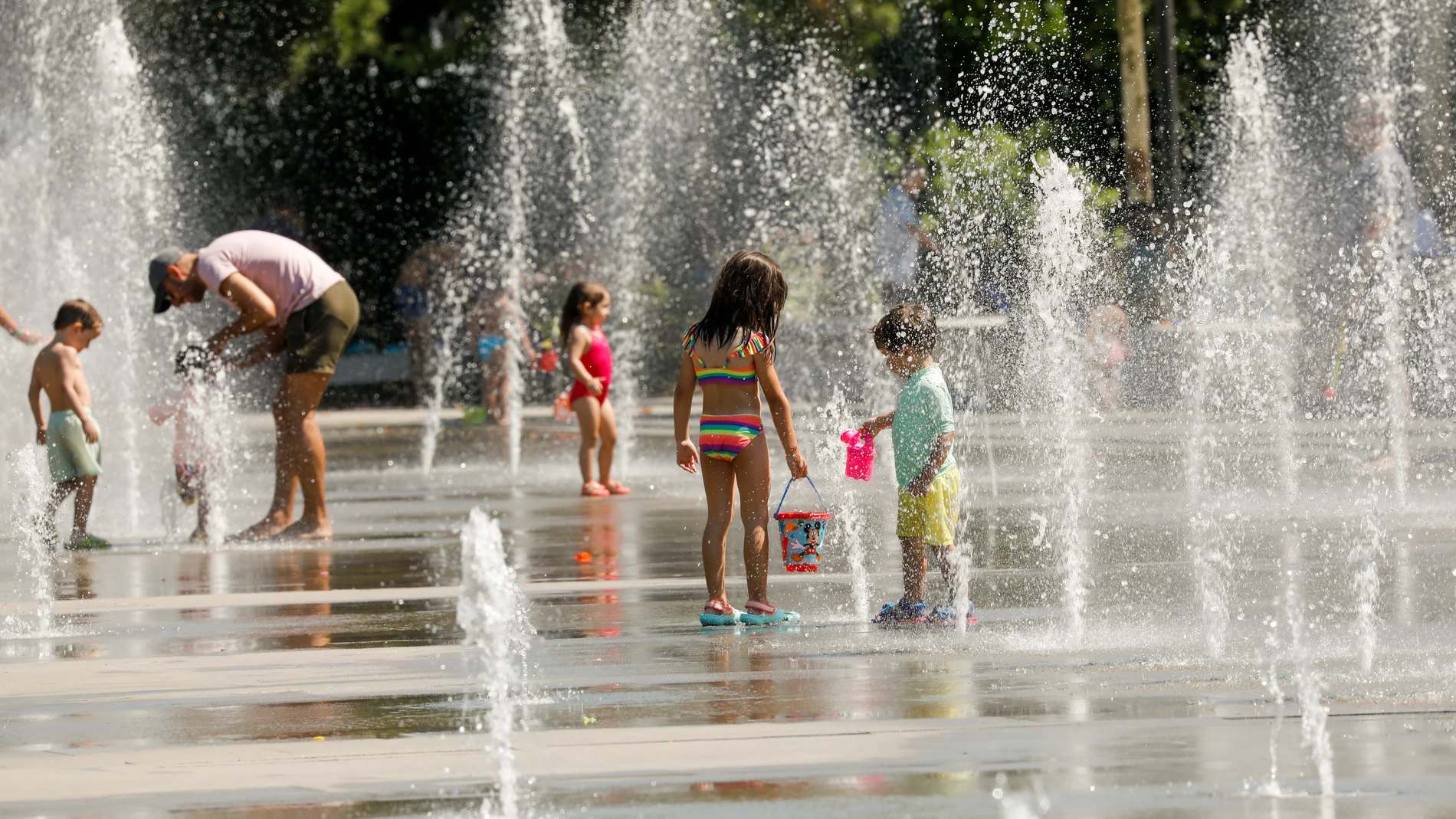 En la imagen, niños y adultos se refrescan en las fuentes del Parque Central de Valencia.