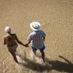 Una pareja pasea por la orilla de la playa