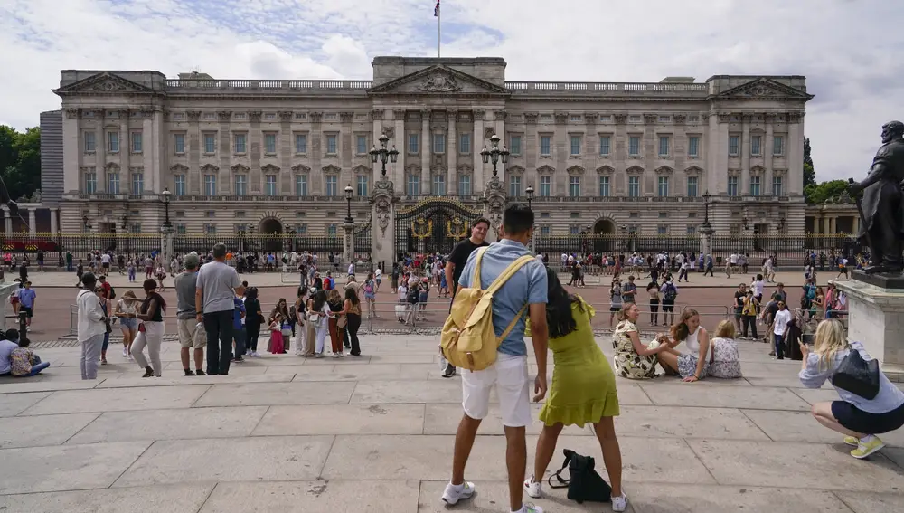 Turistas hacen fotos frente al Palacio de Buckingham, en Londres,