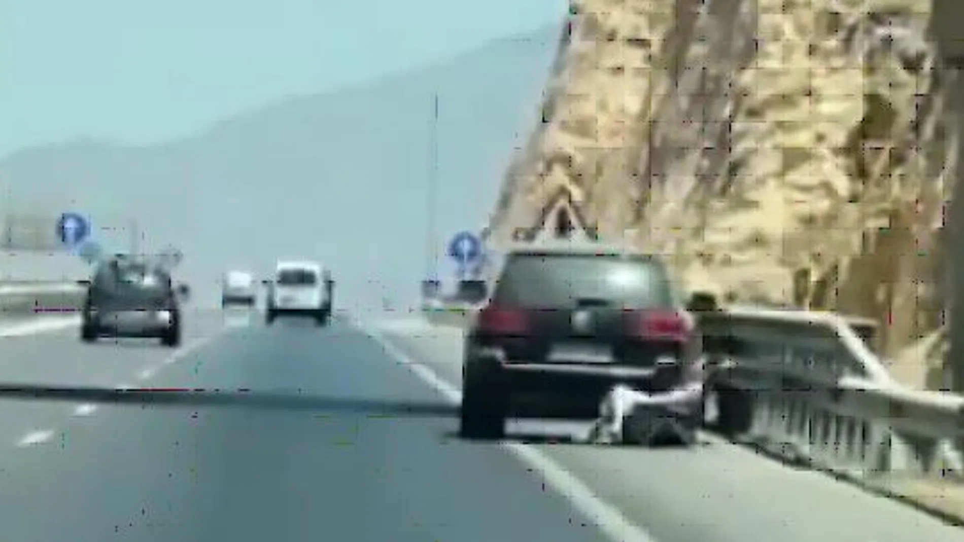 A la derecha, la mujer sentada sobre una tumbona en pleno arcén de la autovía