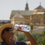 Un turista bebe agua ante la Mezquita-Catedral de Córdoba. EFE/Salas