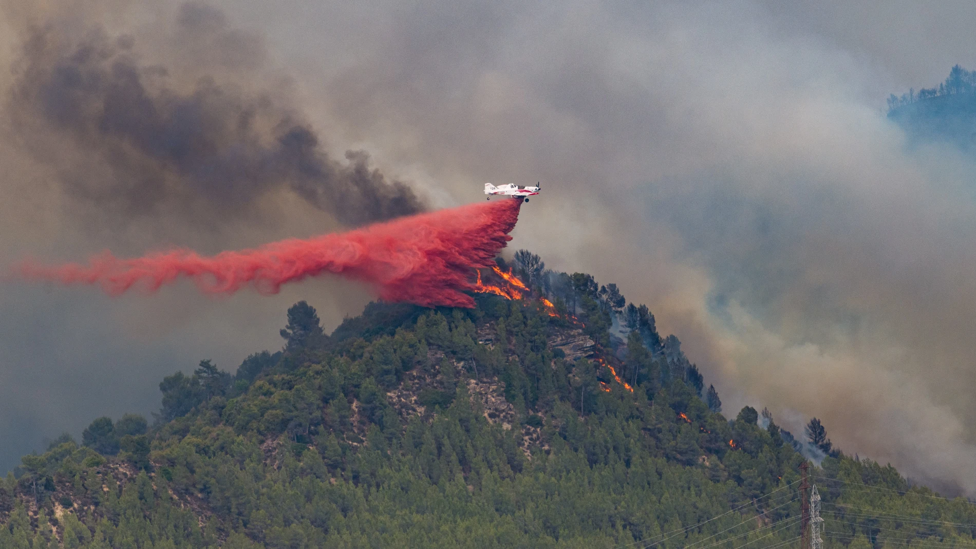 Un hidroavión descarga retardante sobre las llamas de un incendio forestal en a 17 de julio de 2022, en Castellgalí, Barcelona,