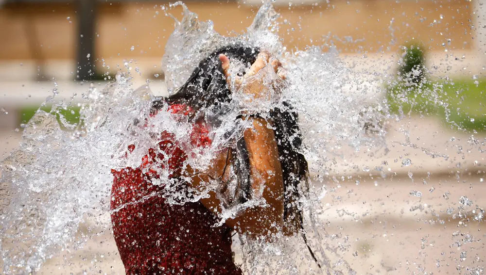Una niña juega en una de las fuentes de Córdoba para aliviar las altas temperaturas | Fuente: EFE/Salas