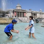 Dos niños juegan en una fuente en Trafalgar Square en Londres