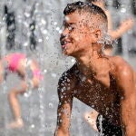Un niño se refresca en una fuente del centro de Duisburg (Alemania), este lunes, durante una jornada de altas temperaturas en el país. EFE/ Sascha Steinbach