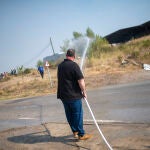 Un civil echa agua a la zona vegetal afectada por un nuevo incendio cerca del antiguo vertedero del Pont de Vilomara. Lorena Sopêna / Europa Press