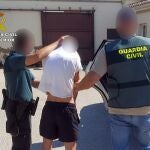 Uno de los detenidos, custodiado por la Guardia Civil