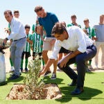 El presidente del Real Betis, Ángel Haro (d) y el capitán del equipo, Joaquín Sánchez (c), siembran un olivo durante el acto de comienzo de las obras de la nueva ciudad deportiva