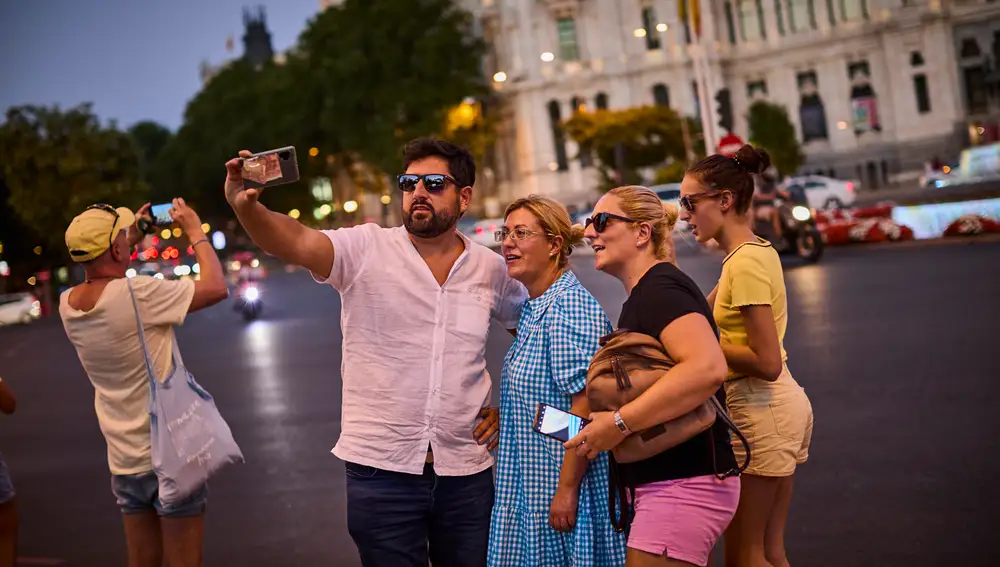 Turistas haciéndose Selfies con su teléfono móvil en la plaza de la cibeles.