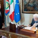 El presidente italiano Sergio Mattarella (derecha) firma la disolución del Parlamento frente a la dimisión del primer ministro italiano, Mario Draghi (izquierda)