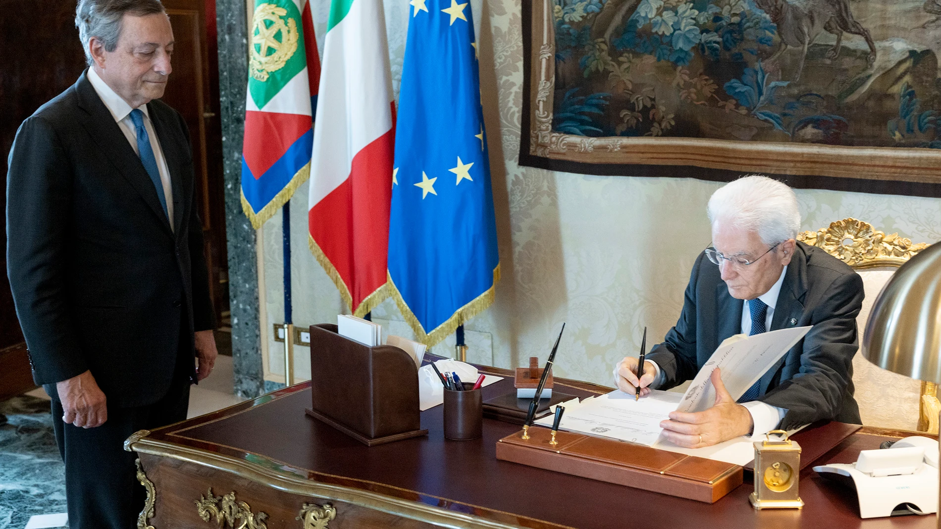 El presidente italiano Sergio Mattarella (derecha) firma la disolución del Parlamento frente a la dimisión del primer ministro italiano, Mario Draghi (izquierda)