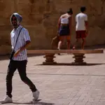 Un turista se protege con un pañuelo por una calle de la Judería de Córdoba