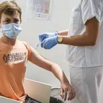 Una sanitaria vacuna a un adolescente con la vacuna Moderna en la Ciudad de las Artes de Valencia
