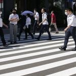 Varias personas con mascarilla caminan por el centro de Tokio (Japón)
