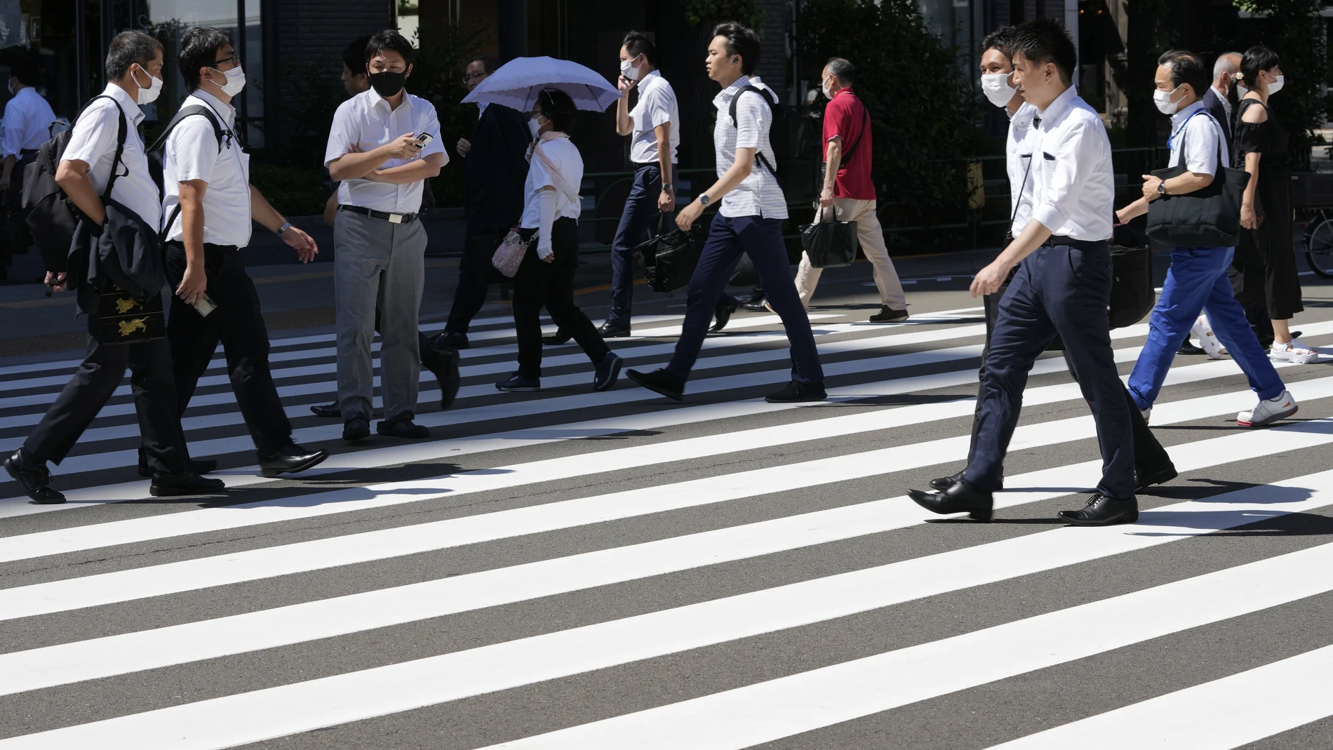 Varias personas con mascarilla caminan por el centro de Tokio (Japón)