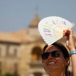 Una mujer se protege del sol con un abanico en Córdoba