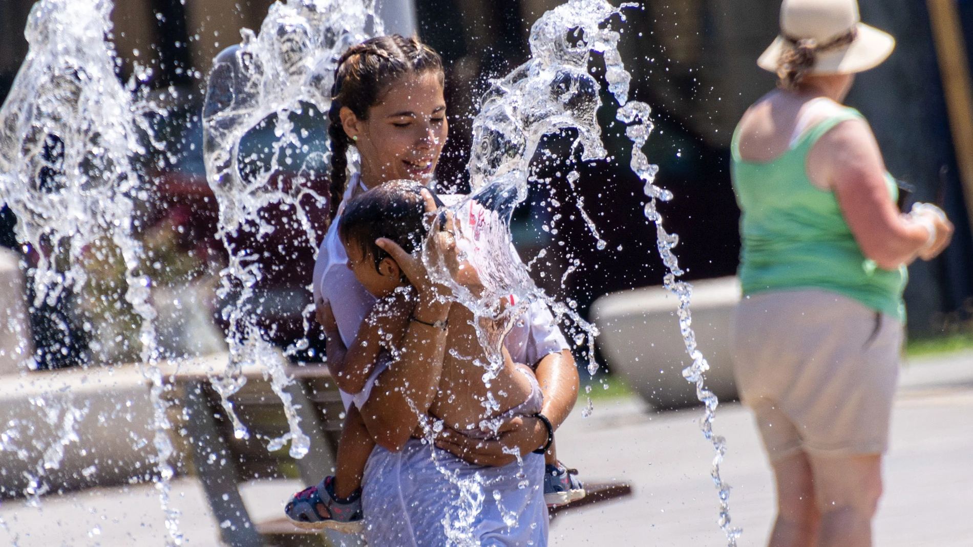 Varias personas se refrescan en el Parque de las Estaciones para combatir el calor, en Palma de Mallorca
