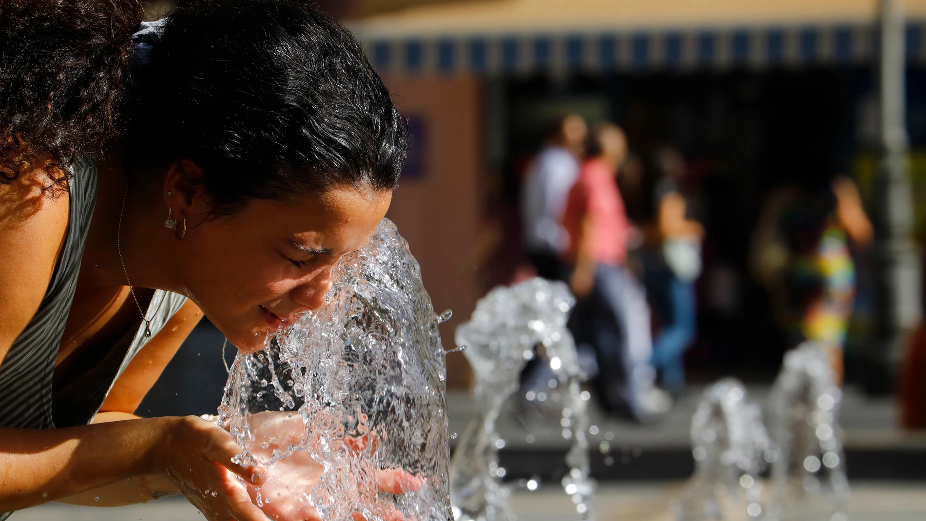 Una mujer se refresca en la fuente de la plaza de las Tendillas de Córdoba