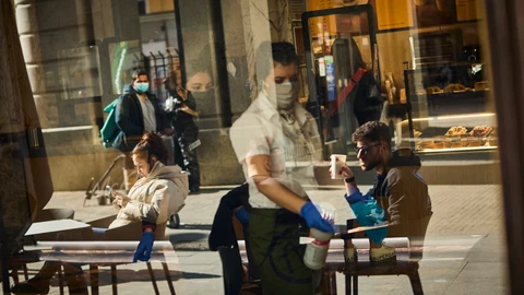 Una camarera en una terraza usando mascarilla