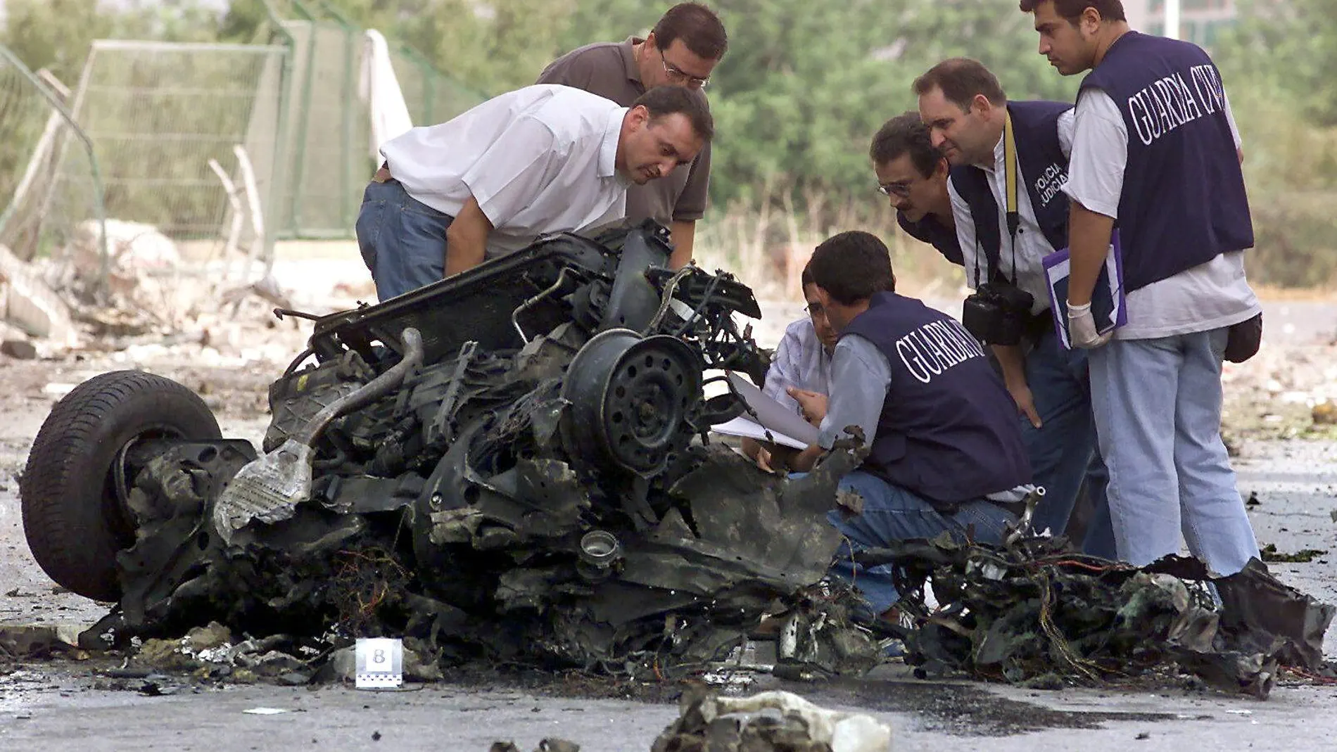Varios guardias civiles examinan los restos del coche bomba utilizado por ETA en el atentado de Santa Pola en 2002