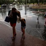 Personas se protegen de la lluvia en el distrito madrileño de Villaverde el pasado 4 de agosto