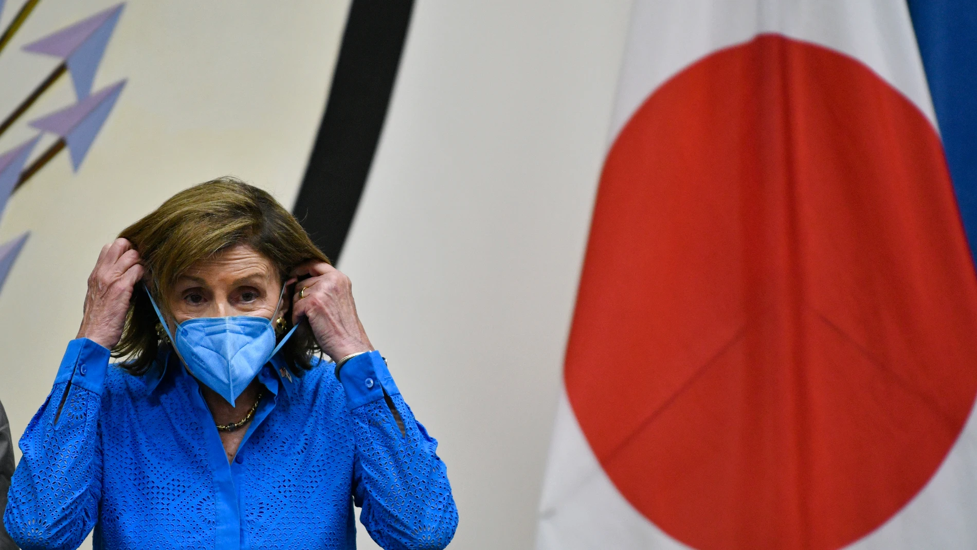 La presidenta de la Cámara de Representantes, Nancy Pelosi, se pone la mascarilla durante una rueda de prensa en Tokio