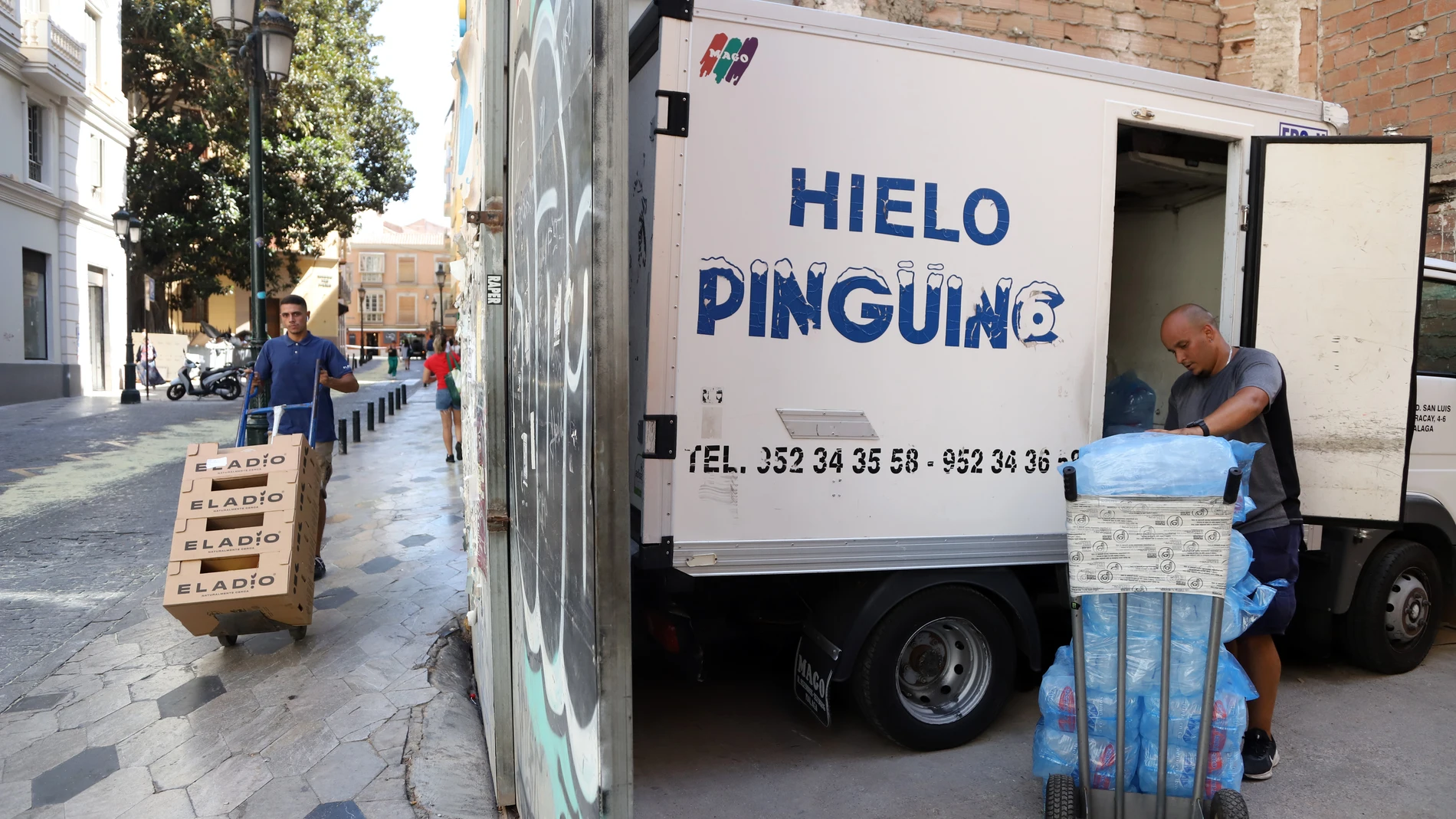 Un repartidor de hielo hace su ruta por los locales del centro Málaga