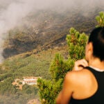 Una mujer observa la columna de humo junto a la urbanización El Picadero, de Pedro Bernardo, que tuvo que ser desalojada de manera preventiva por la cercanía de las llamas