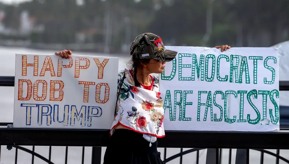 &quot;Los demócratas son fascistas&quot;, se puede leer en este cartel a mano de una simpatizante del ex presidente Trump frente a su residencia de Mar-a-Lago