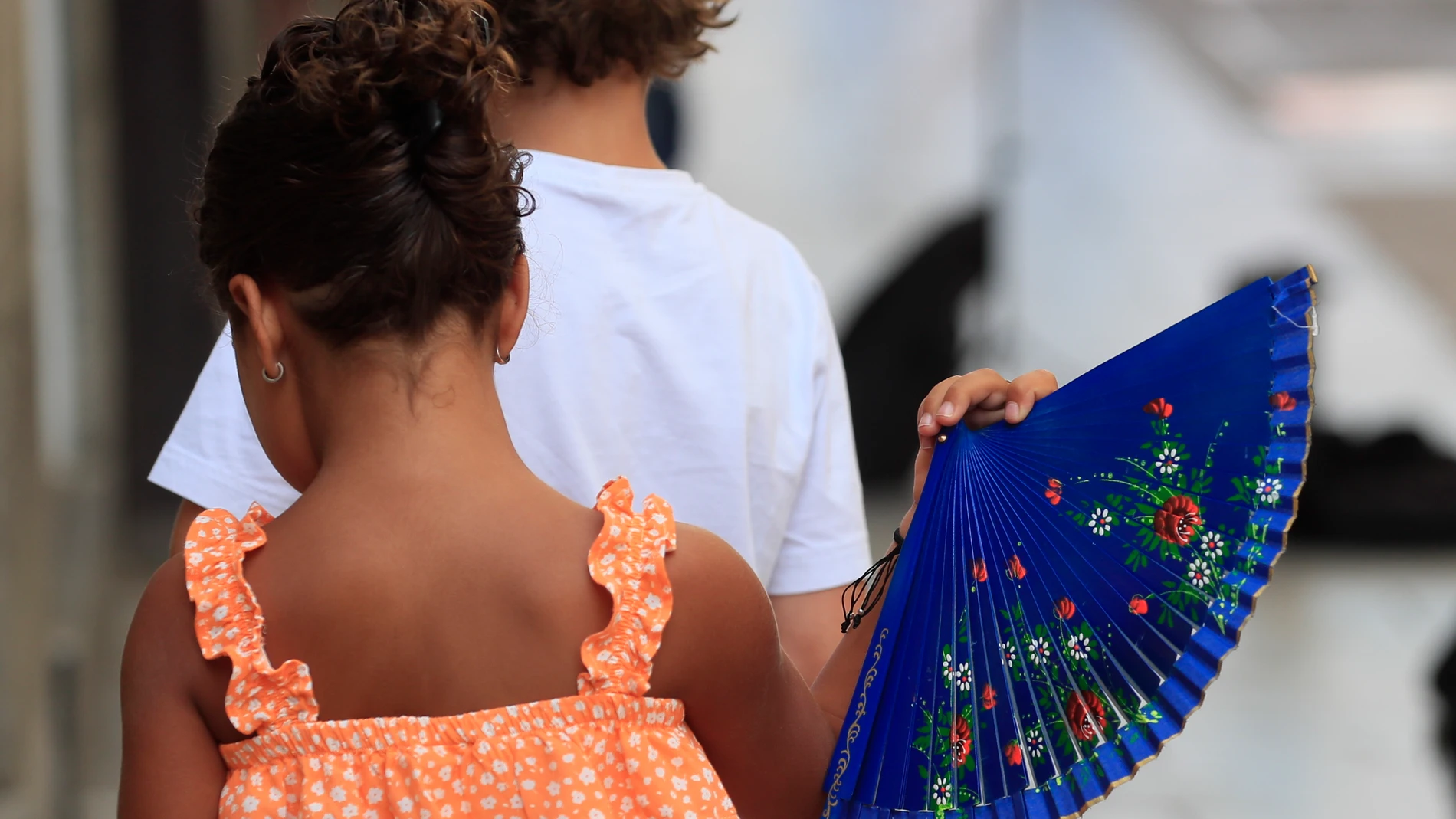 Una niña mitiga el calor con un abanico en Madrid