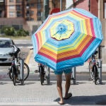 Un hombre con una sombrilla cerca de la Playa de la Malvarrosa, ayer