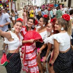 Un grupo de mujeres vestidas de flamencas se fotografía en la calle Larios del centro histórico de la ciudad malagueña, donde se celebra parte de la Feria de Málaga, que ha empezado hoy sábado. EFE/ Daniel Pérez