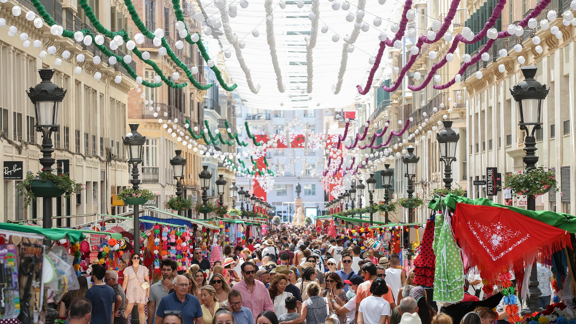 Una multitud se congrega en la calle Larios, en el centro histórico de la ciudad, este lunes, durante las celebraciones por la Feria de Málaga. EFE/ Daniel Pérez