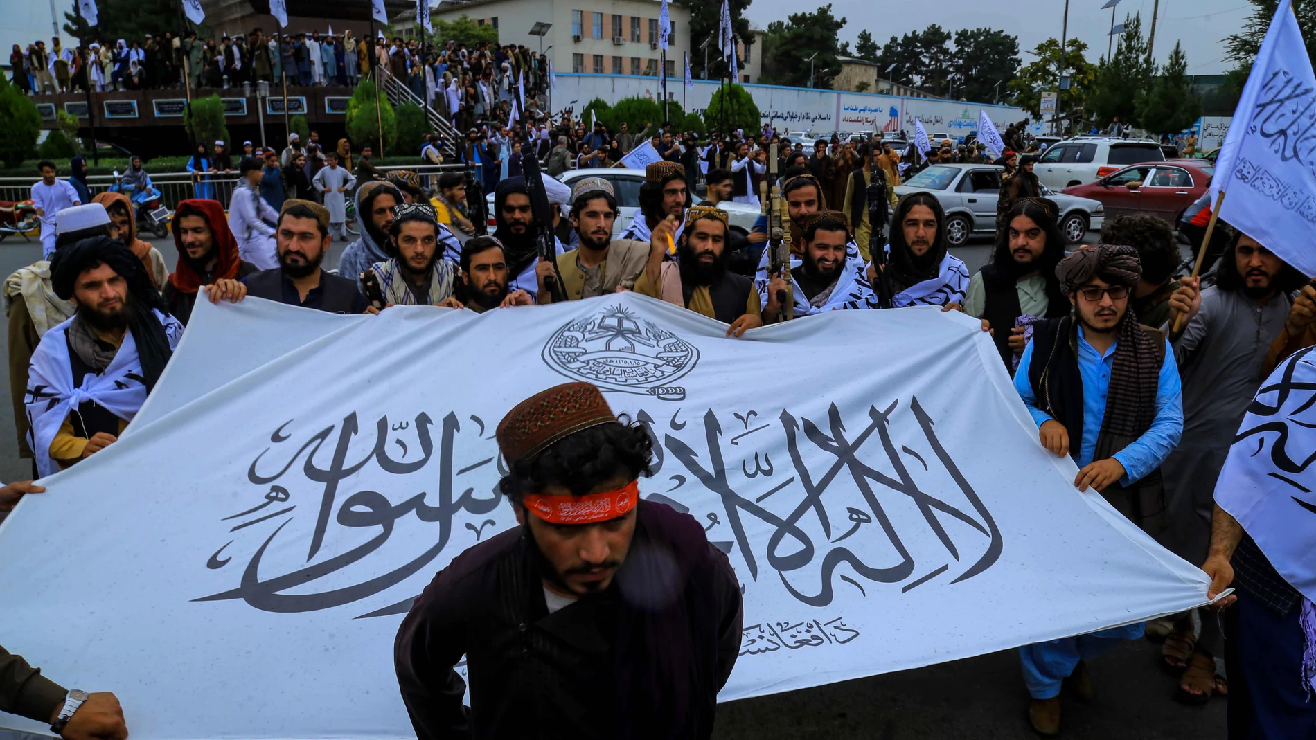 Talibanes exhiben su bandera frente a la Embajada de EE UU en Kabul en el primer aniversario de su toma del poder