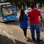 Dos usuarios del transporte público en una parada de la EMT en Madrid