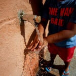 Una persona se refresca en una fuente, en Casa de Campo