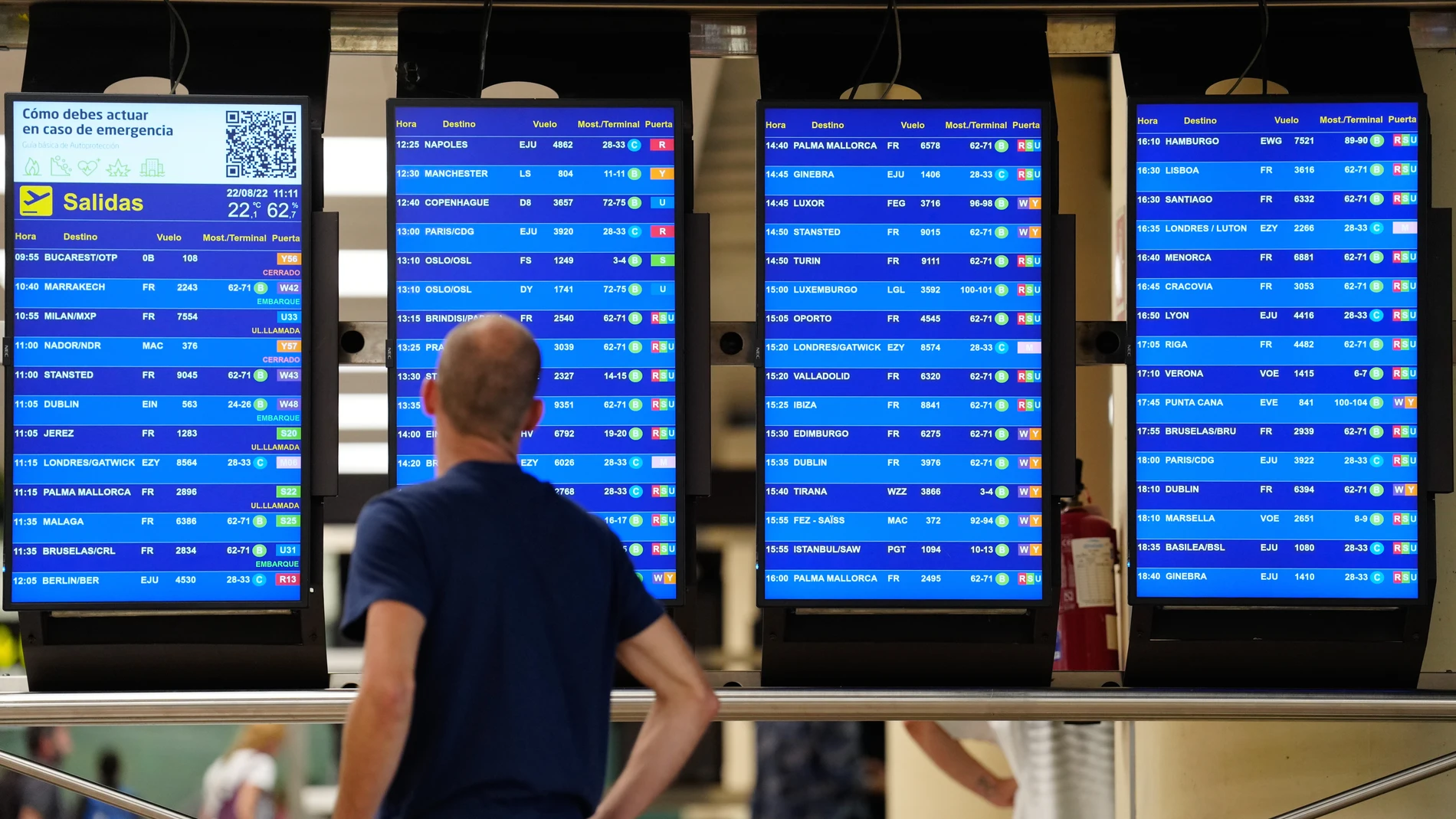 Una pasajero observa un panel informativo en la T2 del Aeropuerto de Barcelona