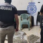 Un agente de Vigilancia Aduanera y otro de la Policía Nacional, ante parte de la droga intervenida