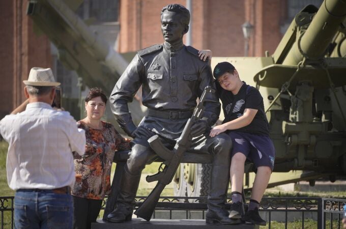La gente posa para una foto en una escultura de Mikhail Kalashnikov, creador del rifle de asalto Kalashnikov en el museo de Artillería en San Petersburgo, Rusia