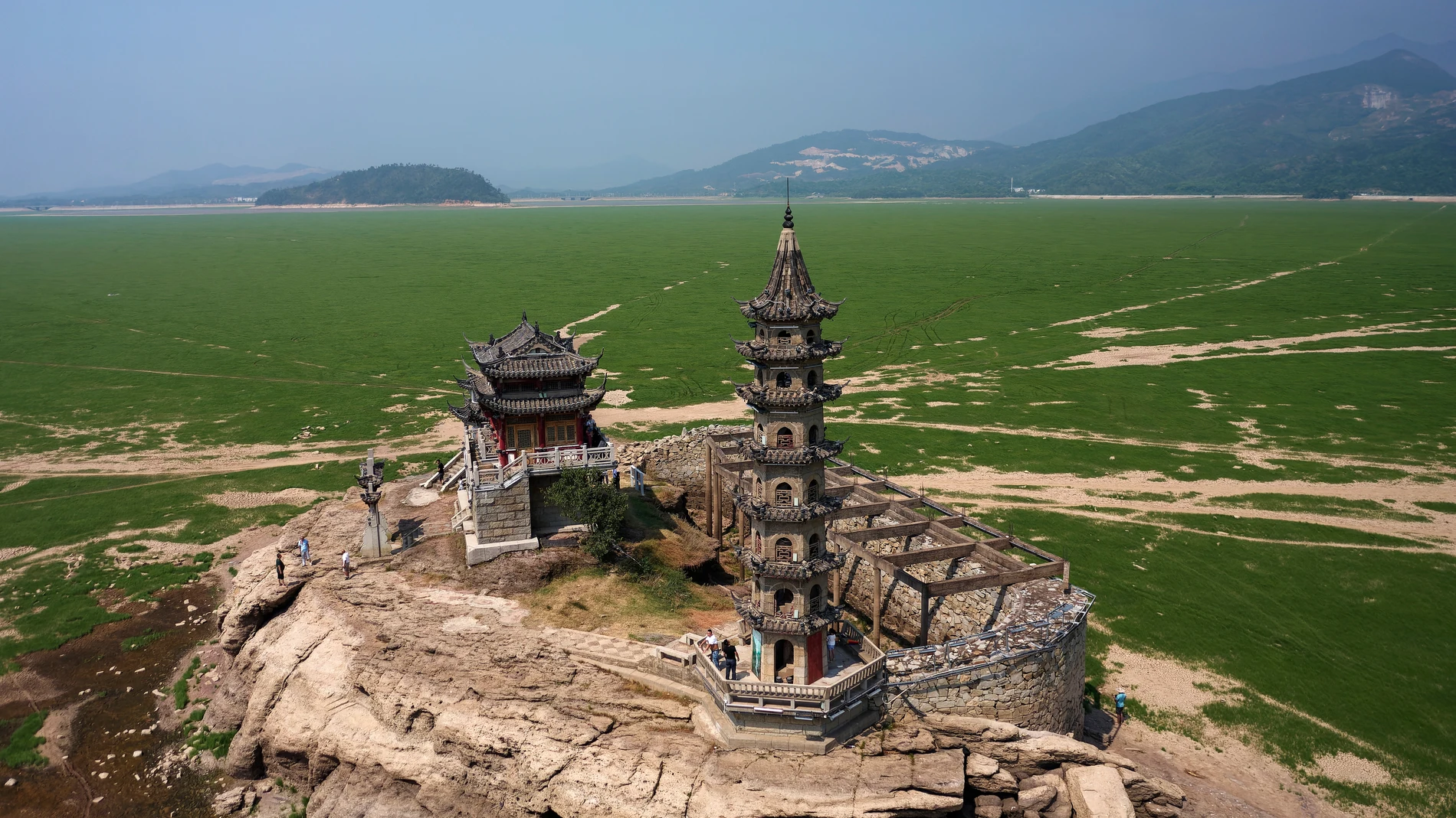 Jiangxi (China), 24/08/2022.- Una fotografía tomada con un dron muestra la isla de piedra de Luoxingdun en el lago Poyang, provincia de Jiangxi, China, este miércoles. Una severa sequía expuso la antigua isla de piedra de Luoxingdun en medio del lago Poyang seco en Este de China. Es la primera vez en 71 años que la isla histórica se puede ver por completo. EFE/ALEX PLAVEVSKI