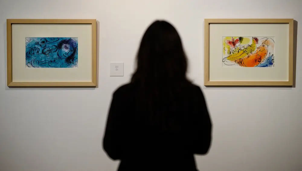 Una mujer observa dos de los cuadros que forman parte de la exposición 'Chagall. Los estados del alma'