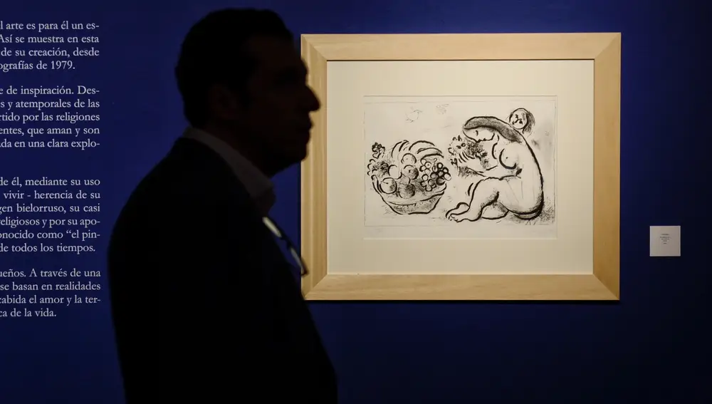 Un hombre camina junto a uno de los cuadros que forman parte de la exposición 'Chagall. Los estados del alma', que presenta 76 obras de uno de los artistas más relevantes del siglo XX, el bielorruso Marc Chagall