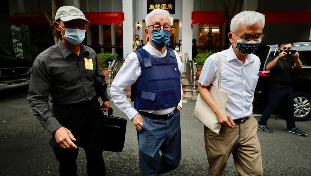 El magnate de los chips Robert Tsao (C), fundador de United Microelectronics Corporation (UMC), lleva un chaleco antibalas mientras camina después de una conferencia de prensa en Taipéi