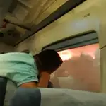 Imagen de uno de los pasajeros dentro del tren frente al incendio de Bejís