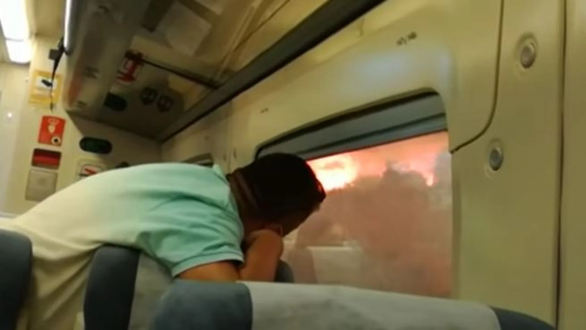 Imagen de uno de los pasajeros dentro del tren frente al incendio de Bejís