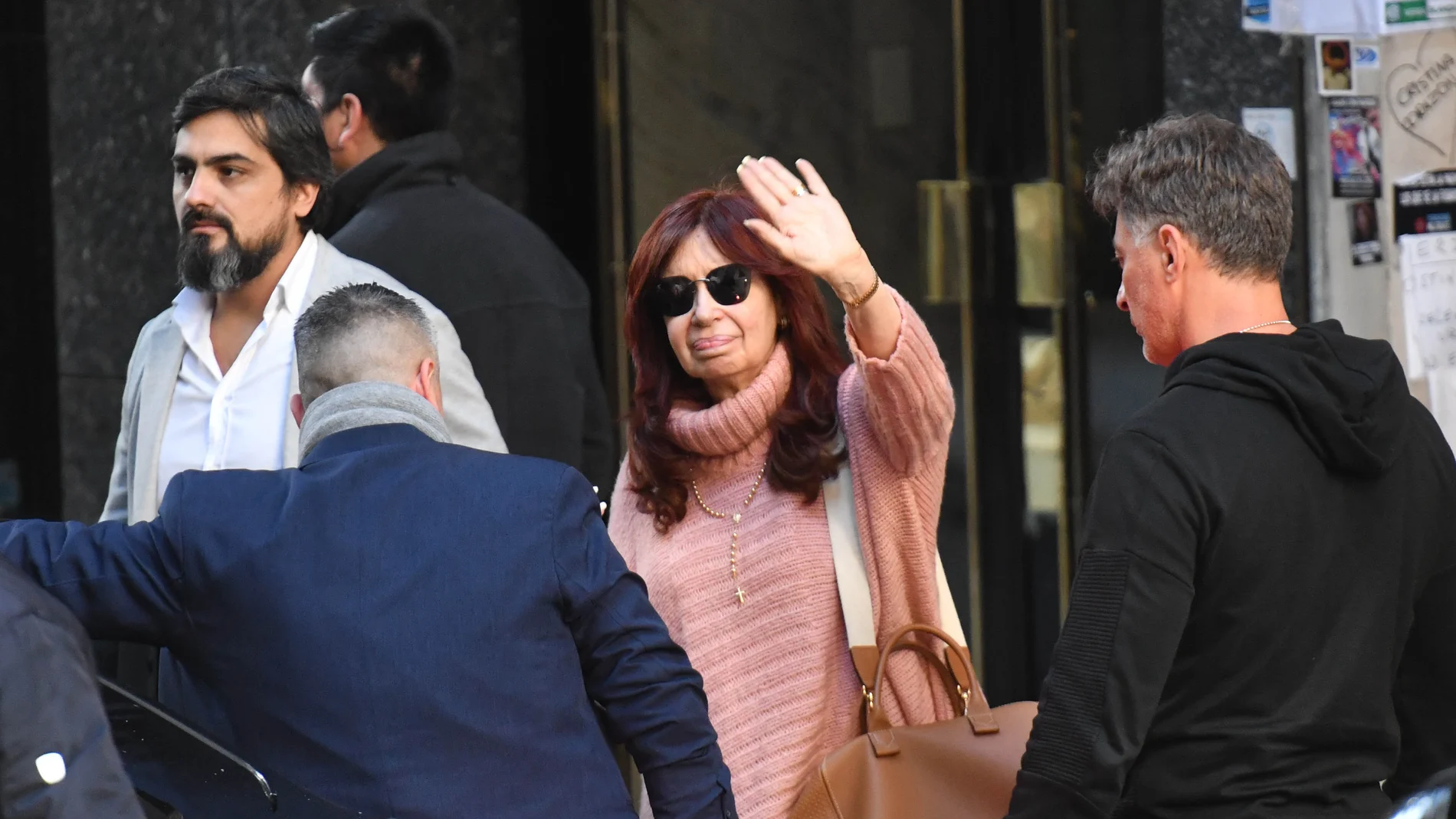 La vicepresidenta de Argentina, Cristina Fernández de Kirchner, saluda a sus simpatizantes mientras sale de su residencia custodiada por un dispositivo de seguridad en Buenos Aires