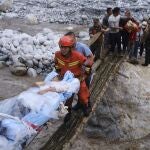 Rescatistas trasladan a los supervivientes través de un río tras el terremoto registrado en la localidad de Moxi del condado de Luding, en la provincia de Sichuan (China)