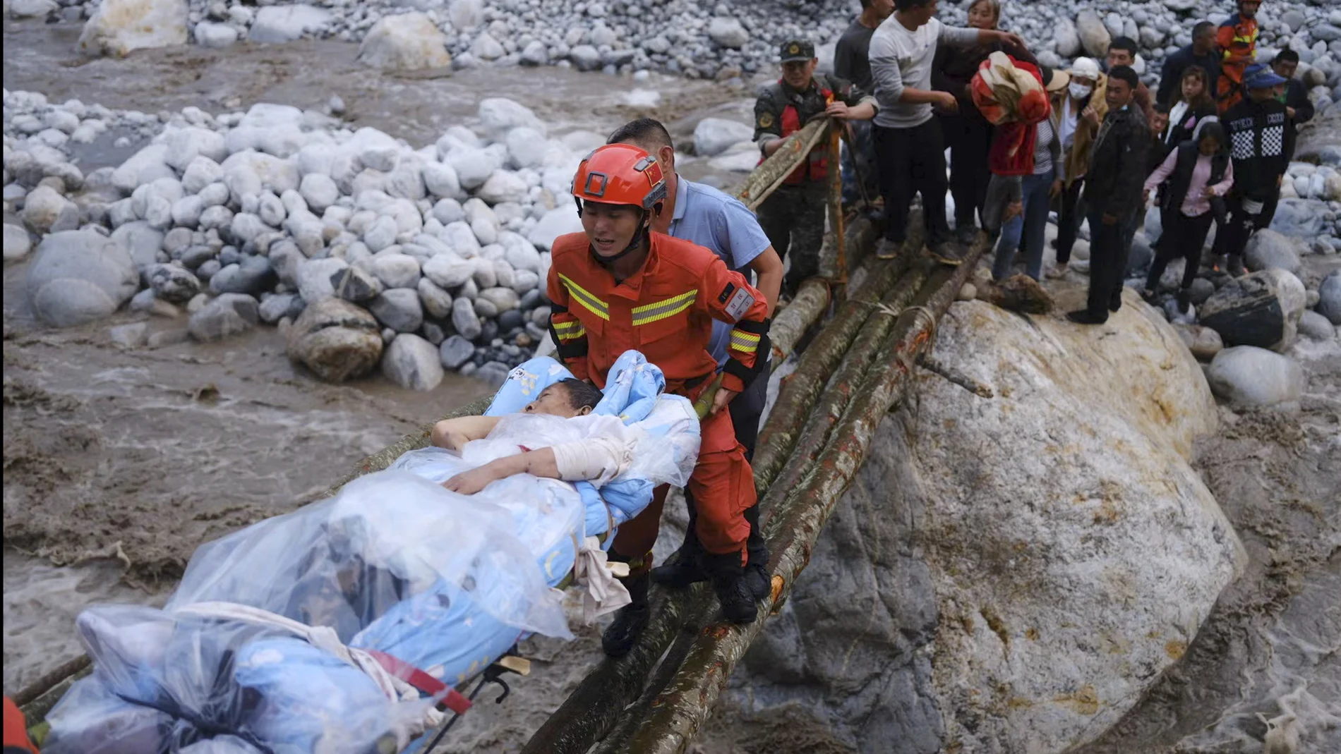 Rescatistas trasladan a los supervivientes través de un río tras el terremoto registrado en la localidad de Moxi del condado de Luding, en la provincia de Sichuan (China)