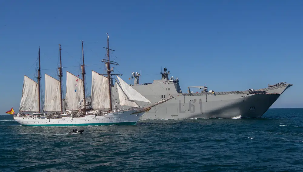 El buque escuela "Juan Sebastián Elcano", con el rey Felipe VI a bordo, junto al buque anfibio portaeronaves "Juan Carlos I" en aguas de Sanlúcar de Barrameda (Cádiz) durante la revista naval. EFE/ Román Ríos