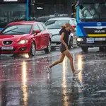 Varias personas se protegen de la lluvia en Madrid